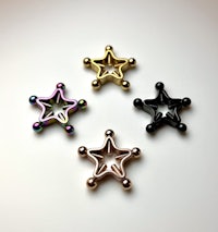 four star shaped piercings on a white surface